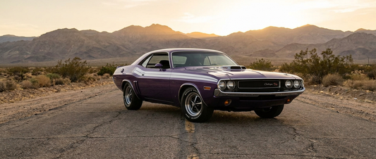 Purple 1970 Dodge Challenger R/T with a shaker hood scoop on a desert two-lane