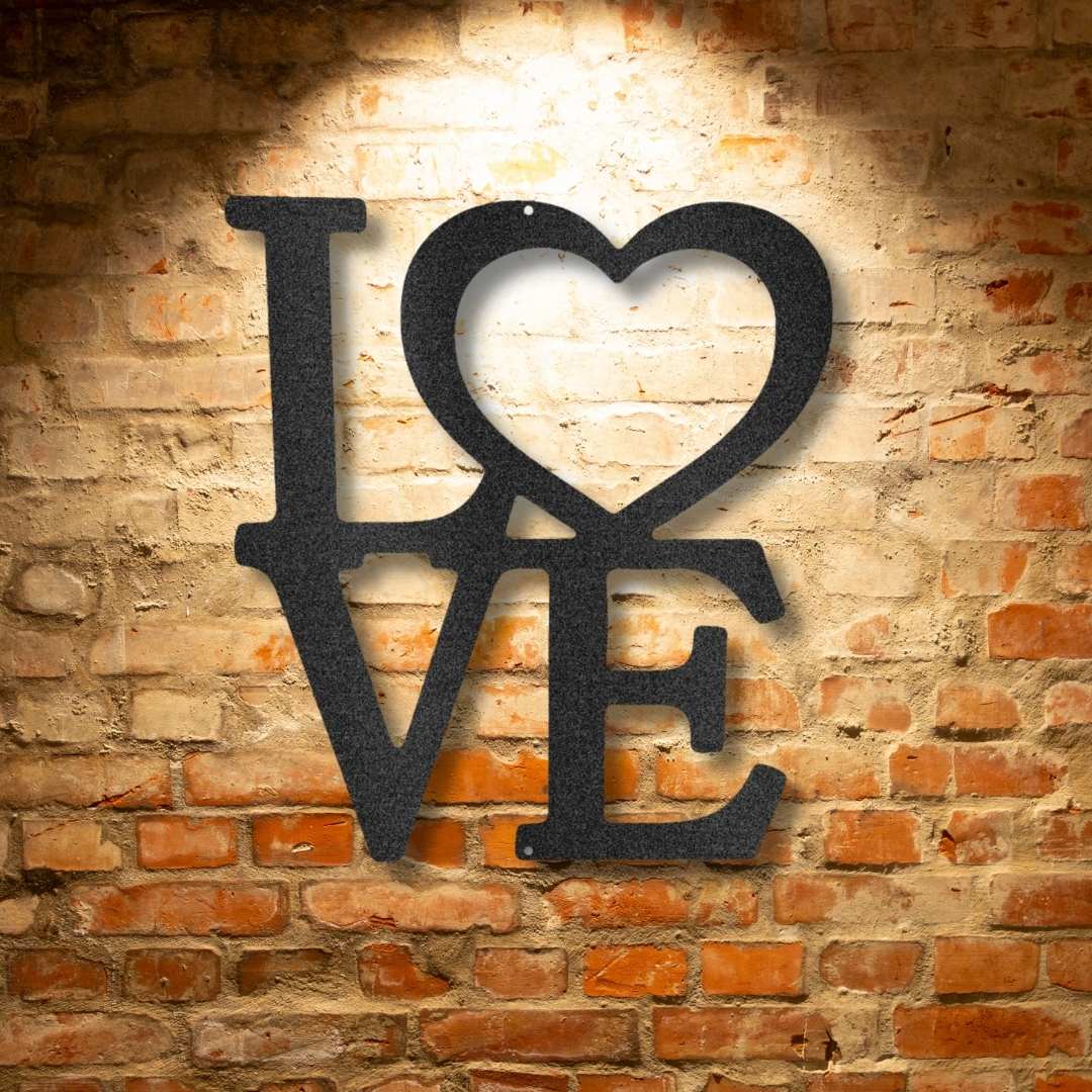 A black metal sign with the word love on a brick wall.