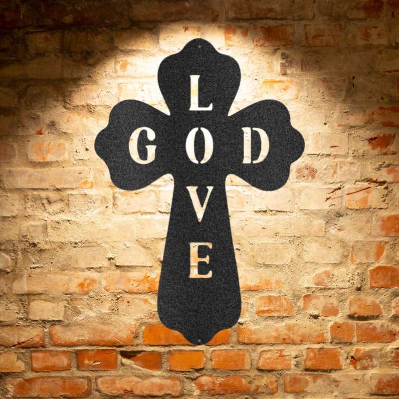 A cross with the word love on it against a brick wall.