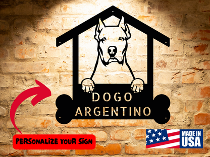 A Personalized Dogo Argentino Dog Name Sign, Custom Dog Breed Steel Monogram Wall Art Decor, Gift for Dogo Argentino Lover featuring a Dogo Argentino dog design, mounted on a brick wall. Text reads, "DOGO ARGENTINO." Includes a "PERSONALIZE YOUR SIGN" arrow for a Custom Dog Breed Wall Art experience and a "Made in USA" label.