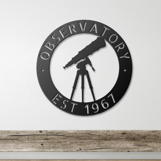 a metal sign with a telescope on it