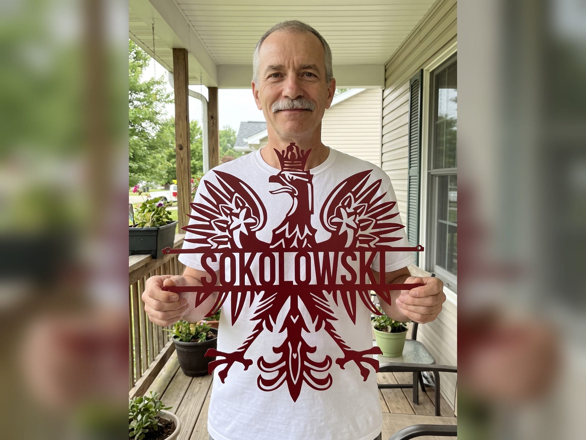 Man holding a red personalized Polish eagle name sign reading SOKOLOWSKI on his front porch