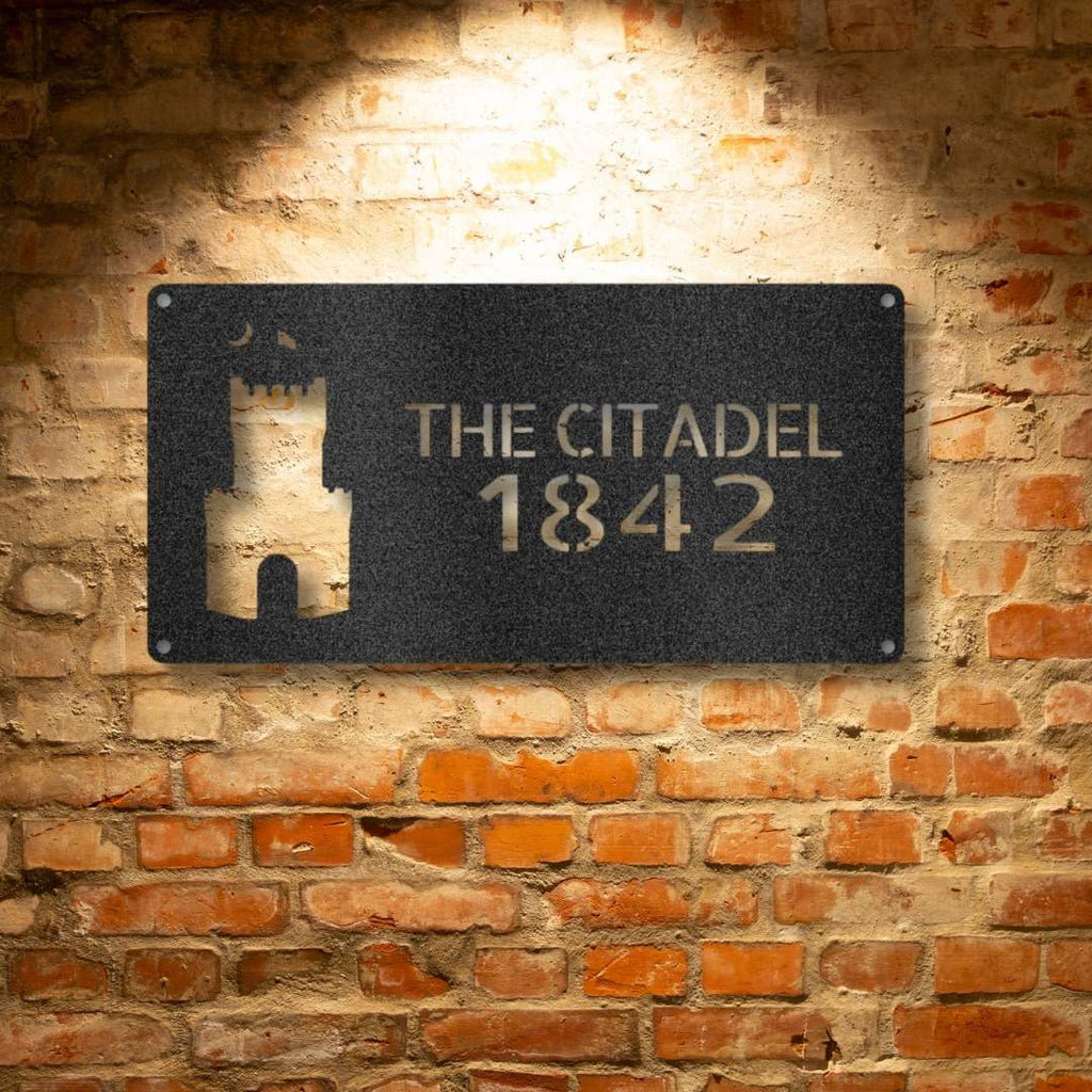 A durable, personalized outdoor metal sign featuring unique metal art gifts, displaying "The Citadel - Steel Sign 1842" on a brick wall.