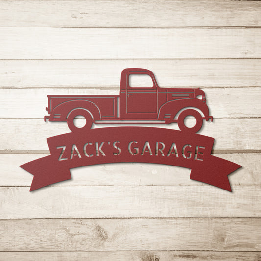 A customized steel monogram sign featuring a red silhouette of a 1941 Dodge WC Pickup, with "Zack's Garage" written below, set against a wooden background. This design exudes nostalgia much like a classic metal sign.