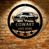 A personalized Camaro Monogram - Steel Sign featuring the cowart and sons logo displayed on a brick wall.