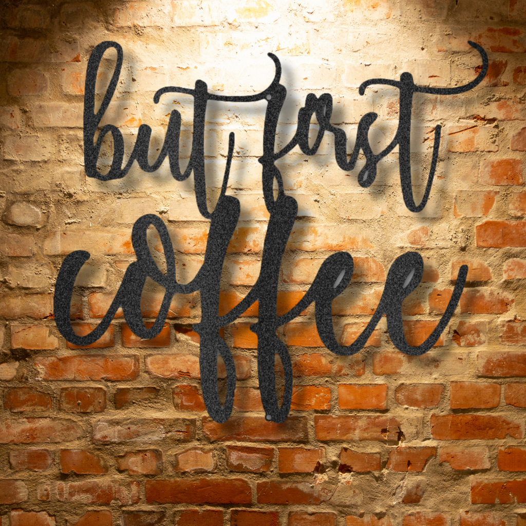 A durable outdoor metal sign portraying a unique and quirky "But First Coffee" quote on a brick wall.