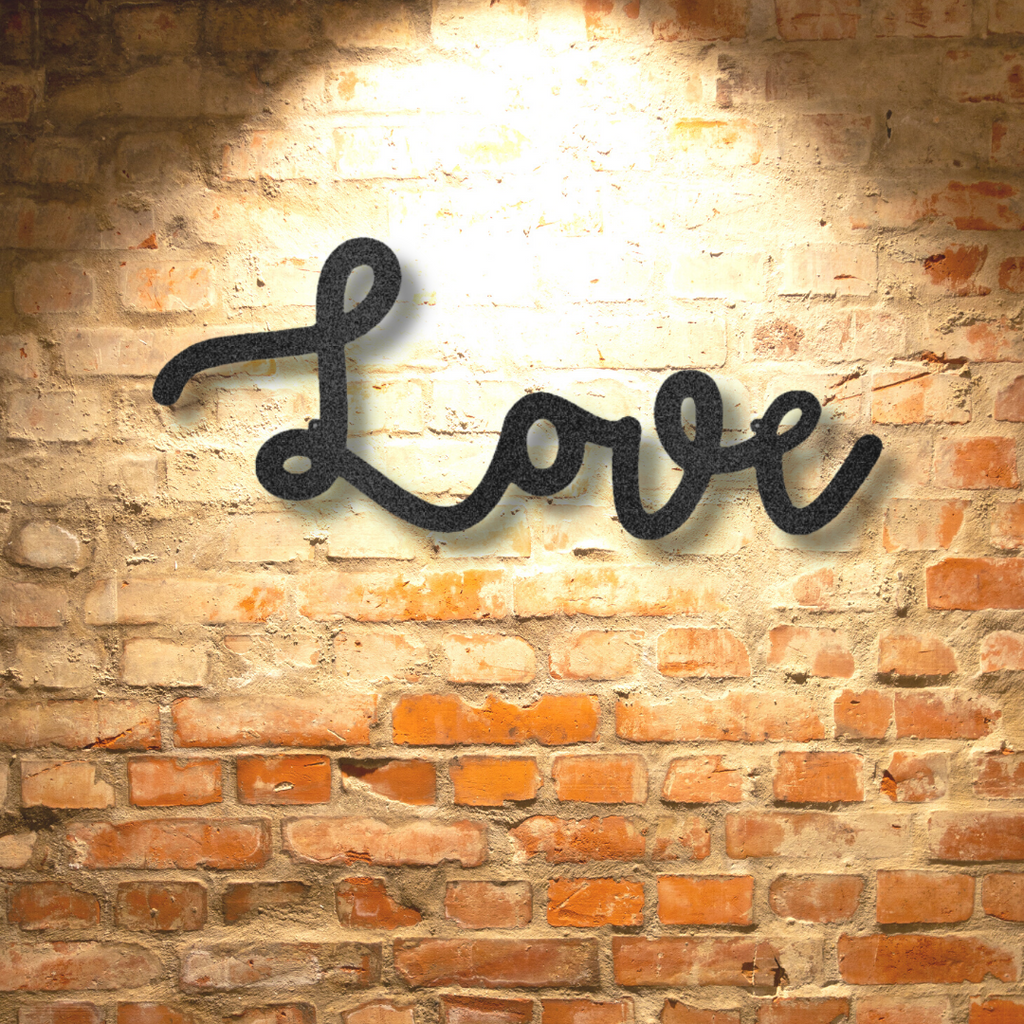 A Personalized Steel Monogram love script sign hanging on a brick wall.
