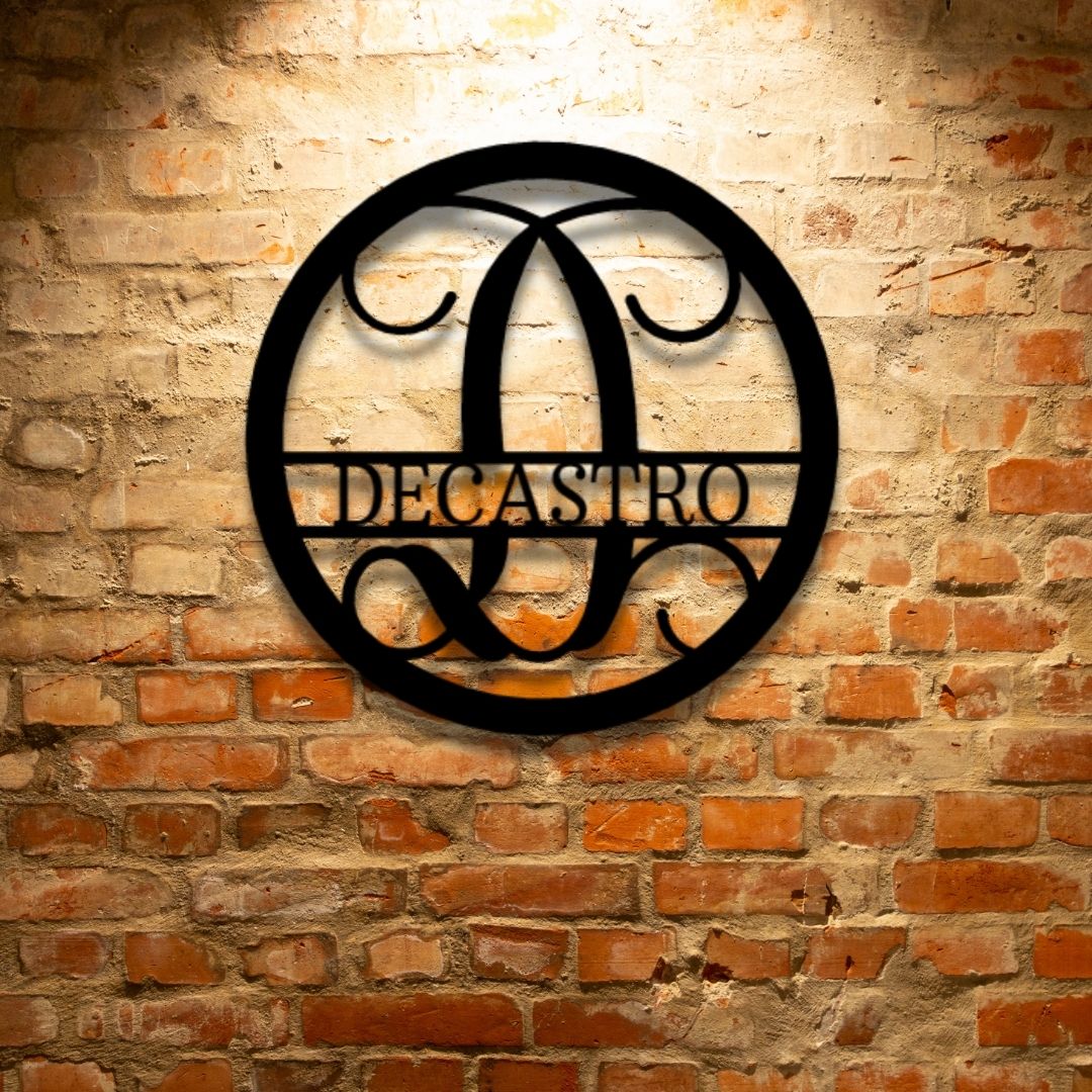 A PERSONALIZED Circle Vine Monogram - Steel Sign with the name decastro hanging on a brick wall as Metal Wall Art Decor