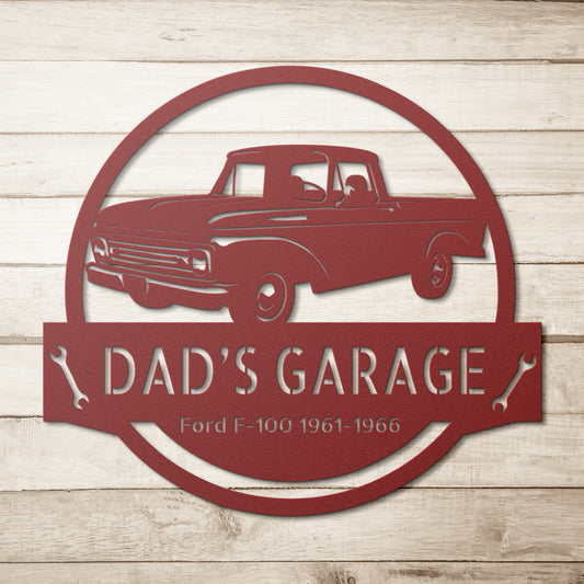 The CAR NAME SIGN - Customized Dad Car Ford F-100 1961-1966 Steel Monogram is a red metal wall art piece, powder-coated for durability, featuring a vintage truck design with "Dad's Garage" and "Ford F-100 1961-1966" on a wooden background. This personalized garage sign brings a nostalgic touch to any space.