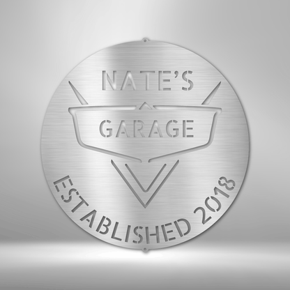 A PERSONALIZED Steel Monogram Garage Decor - Metal Wall Art that says nate's garage established 2018 on a brick wall.