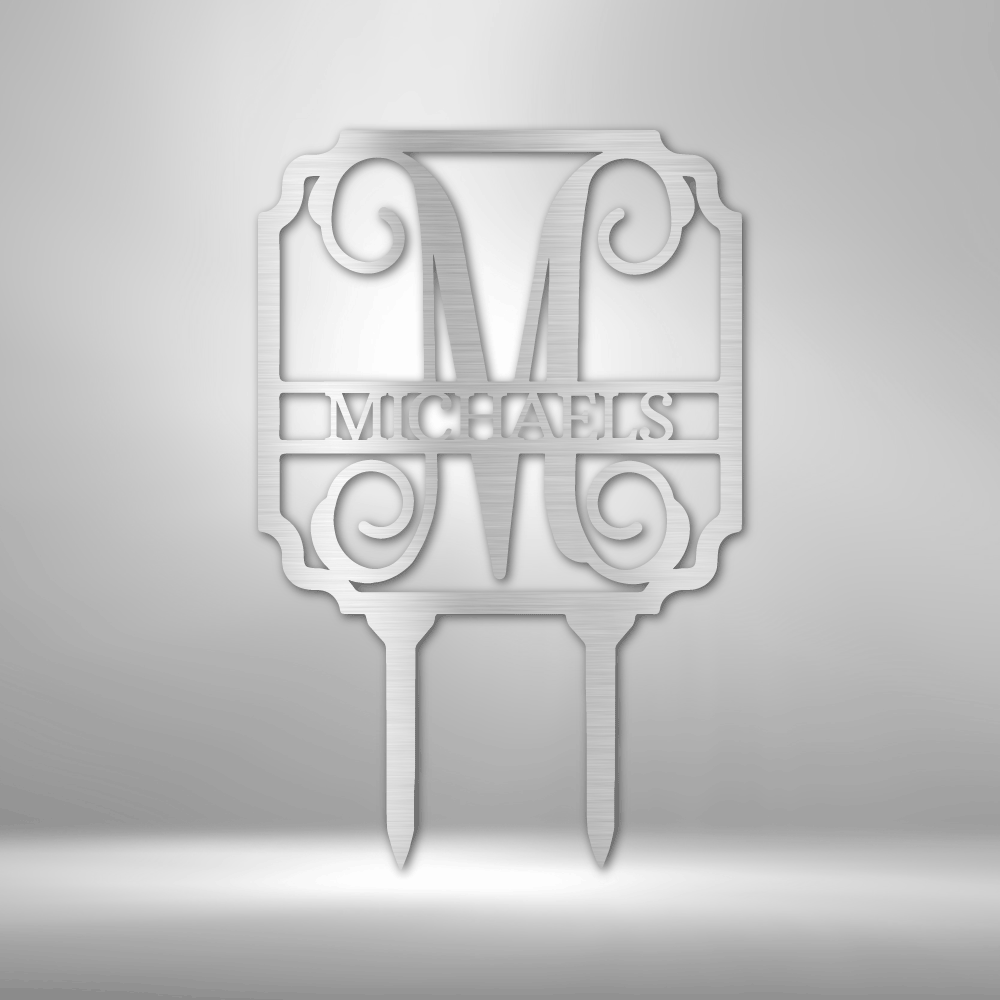 Discover the Vine Stake Monogram - Steel Sign, personalized with a large letter "M" and the word "Michaels" beneath it. This exquisite garden sign features decorative scrollwork and is expertly laser cut with a durable powder-coated finish, designed to stake seamlessly into the ground.