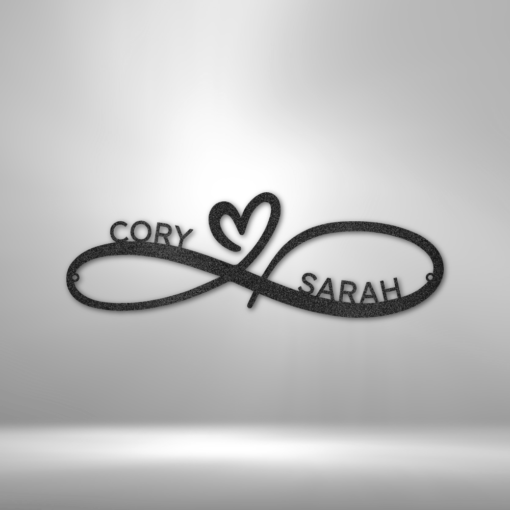 A personalized steel monogram featuring the names cory and sarah, hanging on a brick wall.