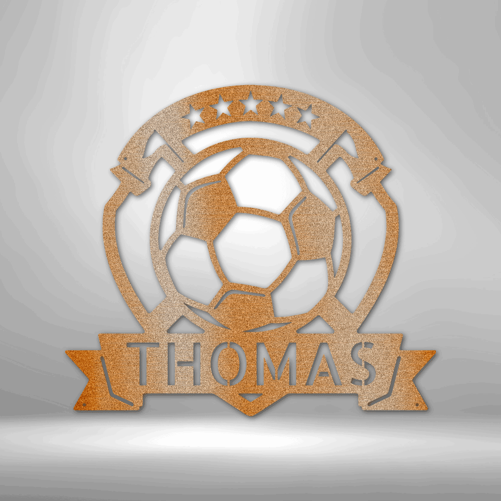 A personalized steel monogram of the name Thomas, displayed as a soccer plaque, adorning a brick wall.