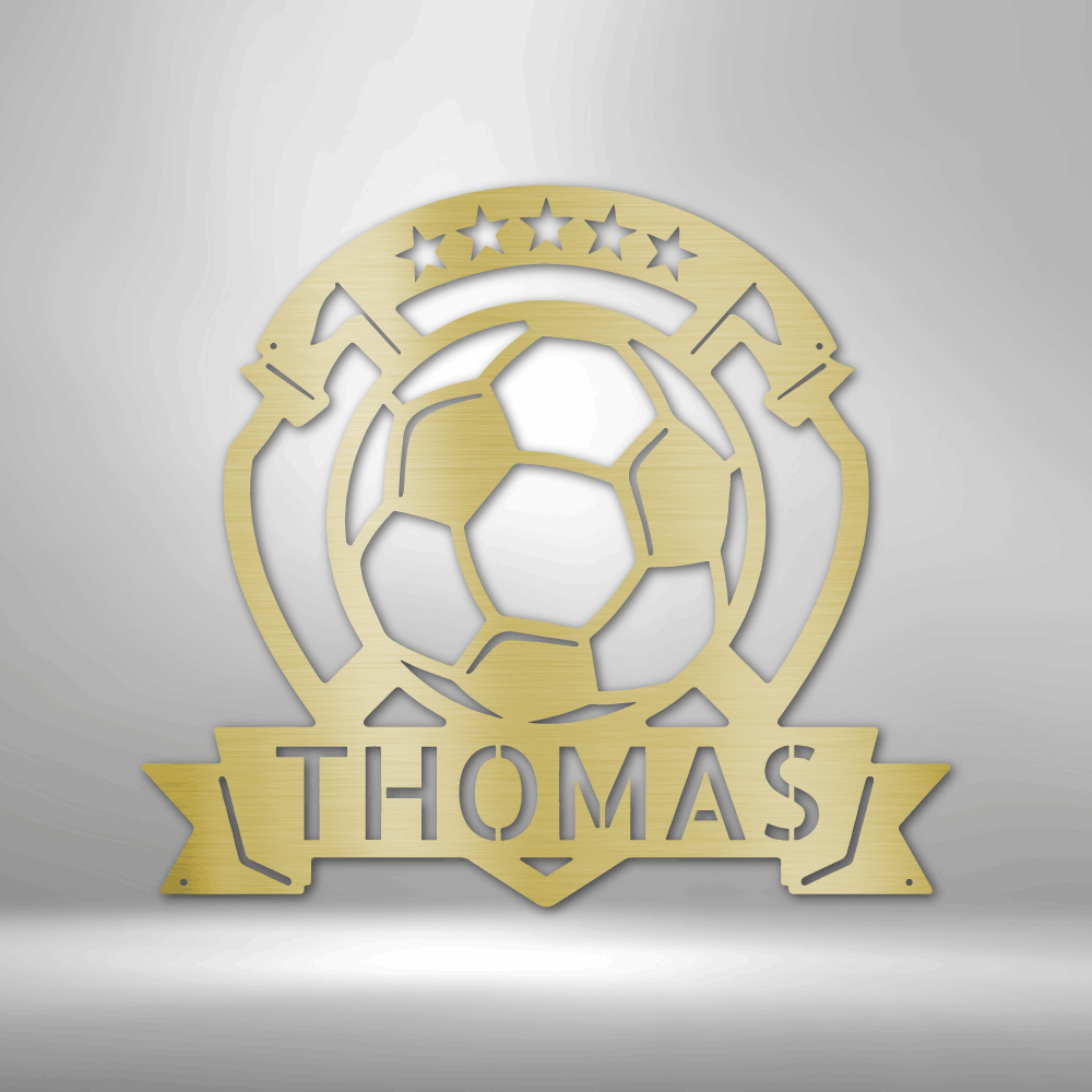 A personalized steel monogram of the name Thomas, displayed as a soccer plaque, adorning a brick wall.