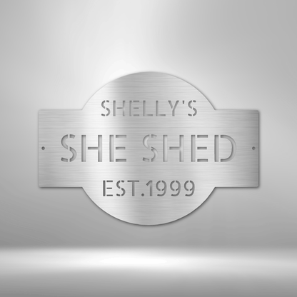 A PERSONALIZED Metal Wall Art Decor plaque that says she shed on a brick wall.