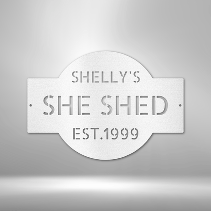 A PERSONALIZED Metal Wall Art Decor plaque that says she shed on a brick wall.