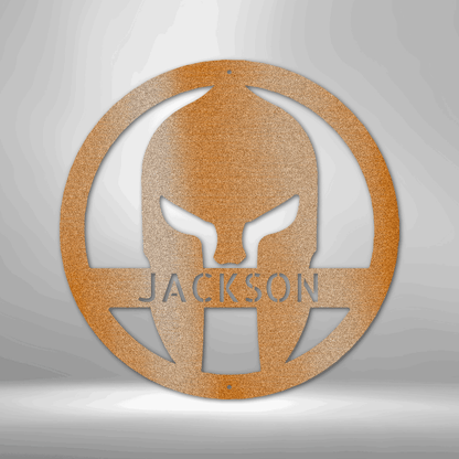 A Durable Outdoor Metal Sign featuring a Custom Handmade Design of a Spartan Helmet with the name Jackson on a brick wall.