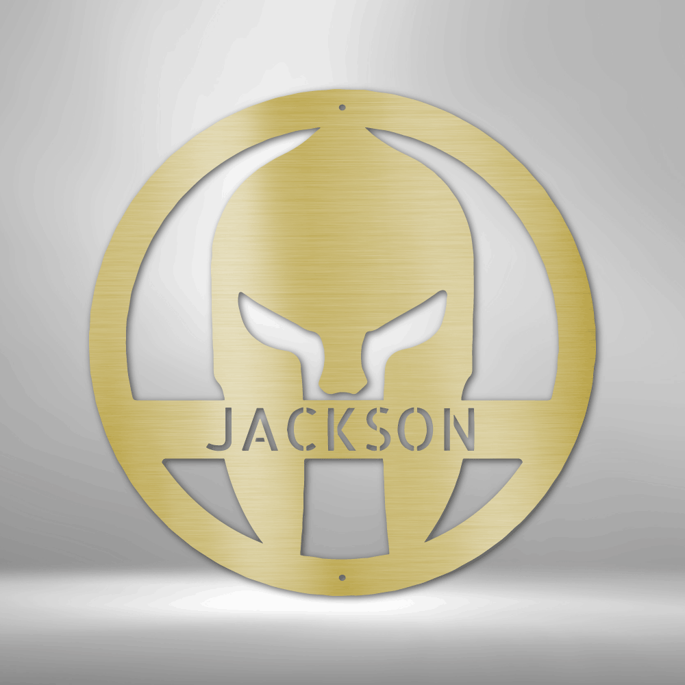 A Durable Outdoor Metal Sign featuring a Custom Handmade Design of a Spartan Helmet with the name Jackson on a brick wall.