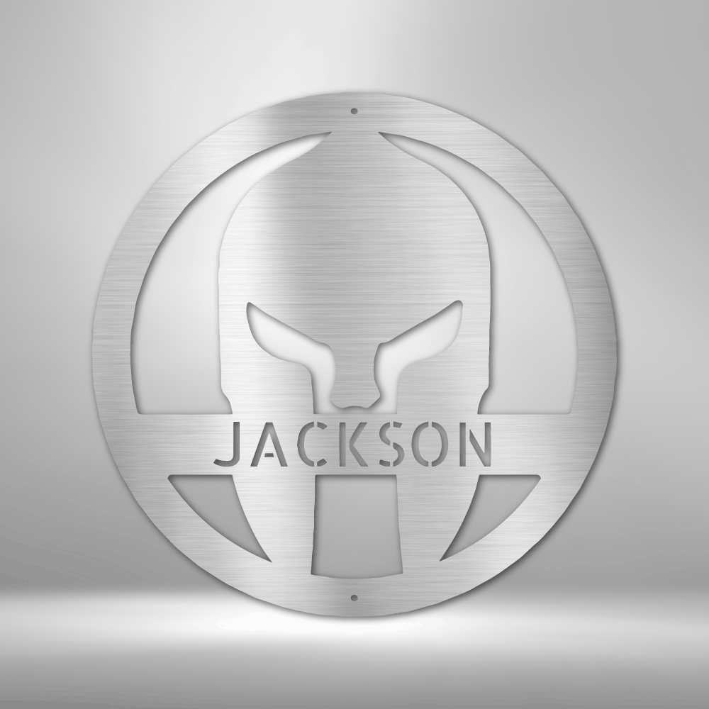 A Durable Outdoor Metal Sign featuring a Custom Handmade Design of a Spartan Helmet with the name Jackson on a brick wall.