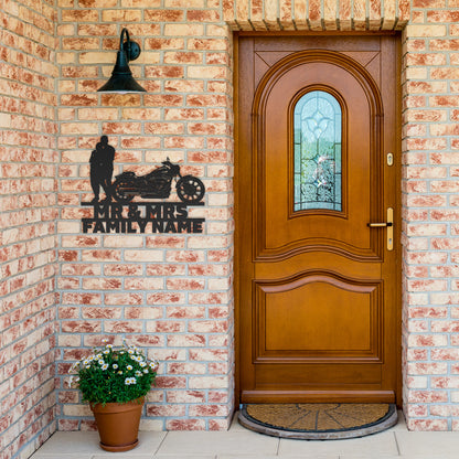 A personalized metal family wall art featuring a silhouette of a Mr&Mrs Harley-Davidson couple SET 13 on a brick wall.