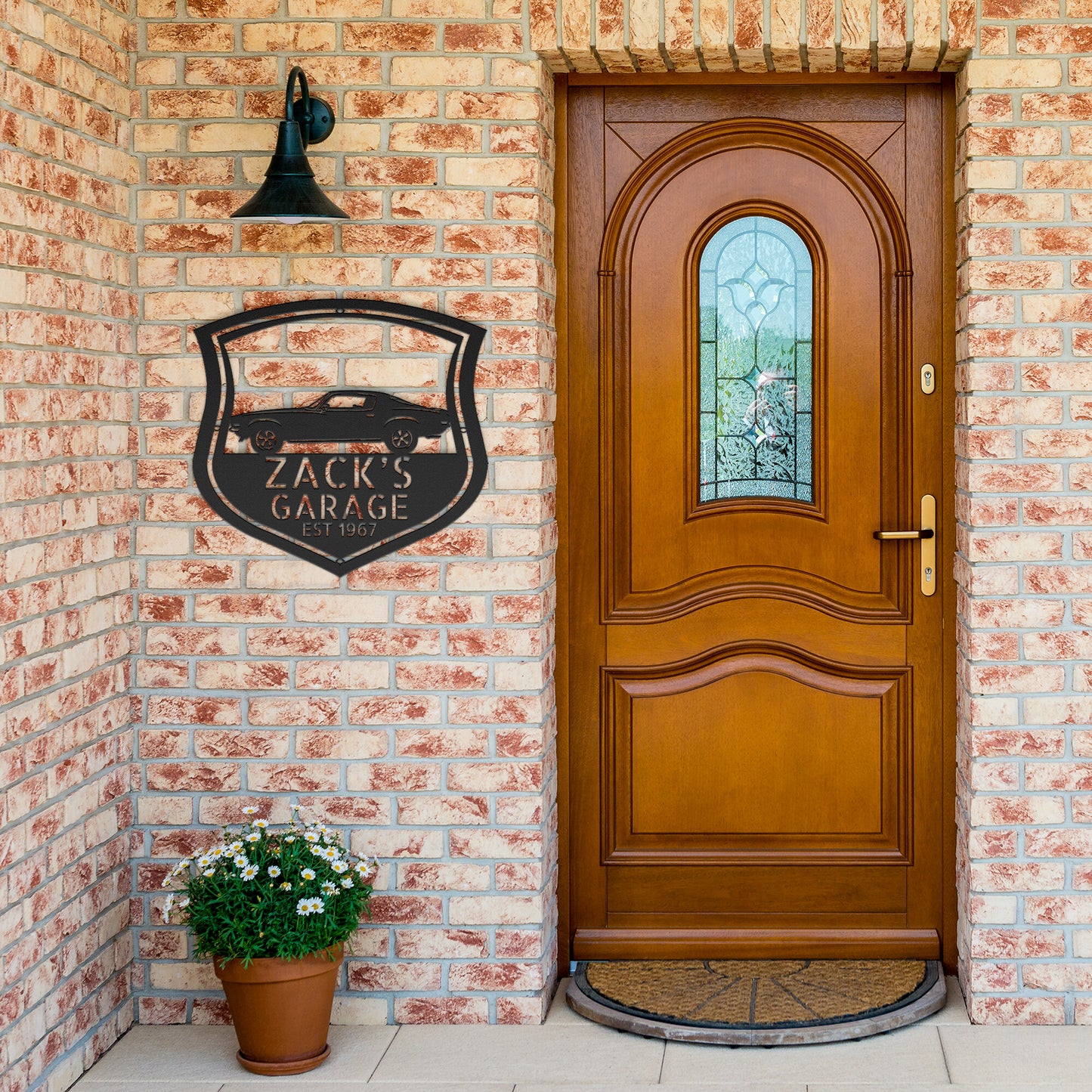 A Vintage Car Monogram Sign with Custom Car Steel Sign features, hanging on a brick wall, makes for a classic addition to any workshop or garage.