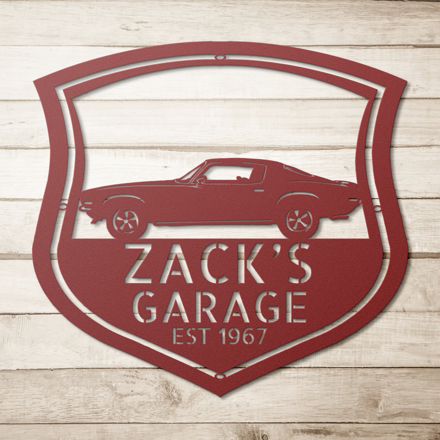 A Vintage Car Monogram Sign with Custom Car Steel Sign features, hanging on a brick wall, makes for a classic addition to any workshop or garage.