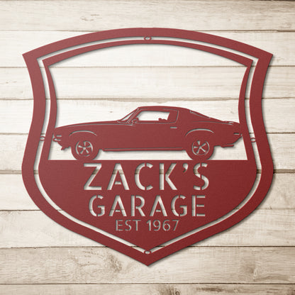 A Vintage Car Monogram Sign with Custom Car Steel Sign features, hanging on a brick wall, makes for a classic addition to any workshop or garage.